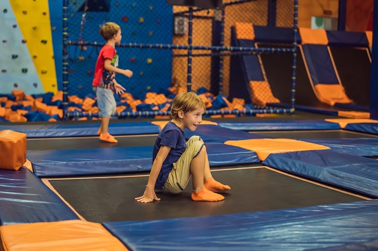 Cute boy jumping on trampoline in entertainment center